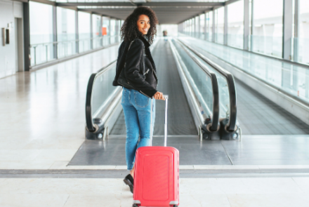 Vrouw met bagage die vertrekt op de luchthaven